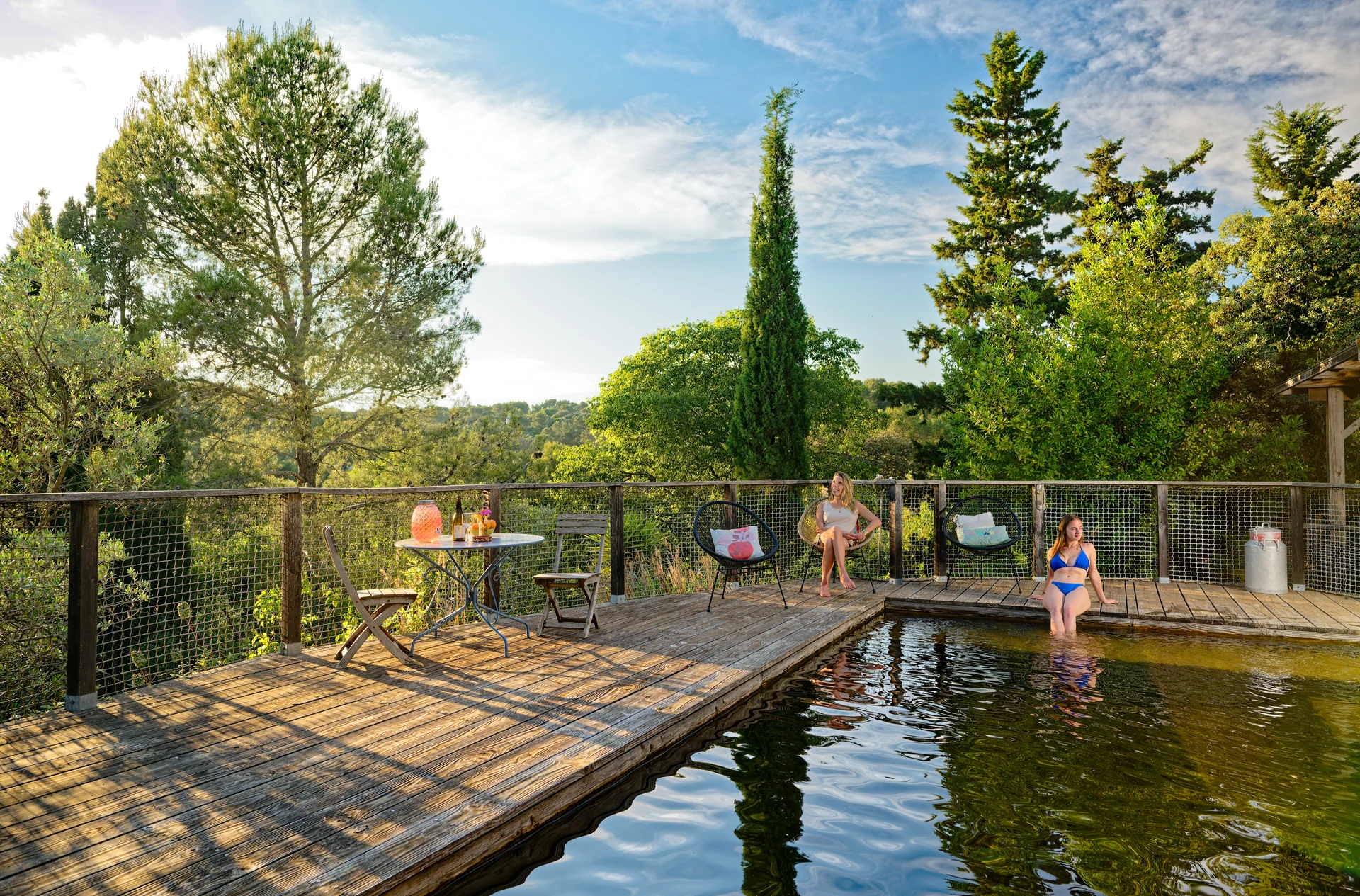 Terrasse en bois au bord de l’eau, entourée de végétation